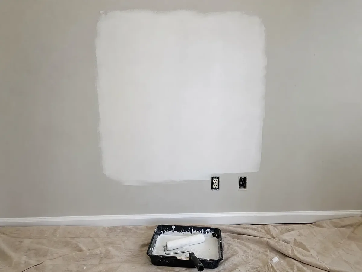 A freshly patched and primed drywall section on an interior wall, smooth and ready for paint